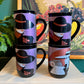 80s glam black mugs with metallic face designs